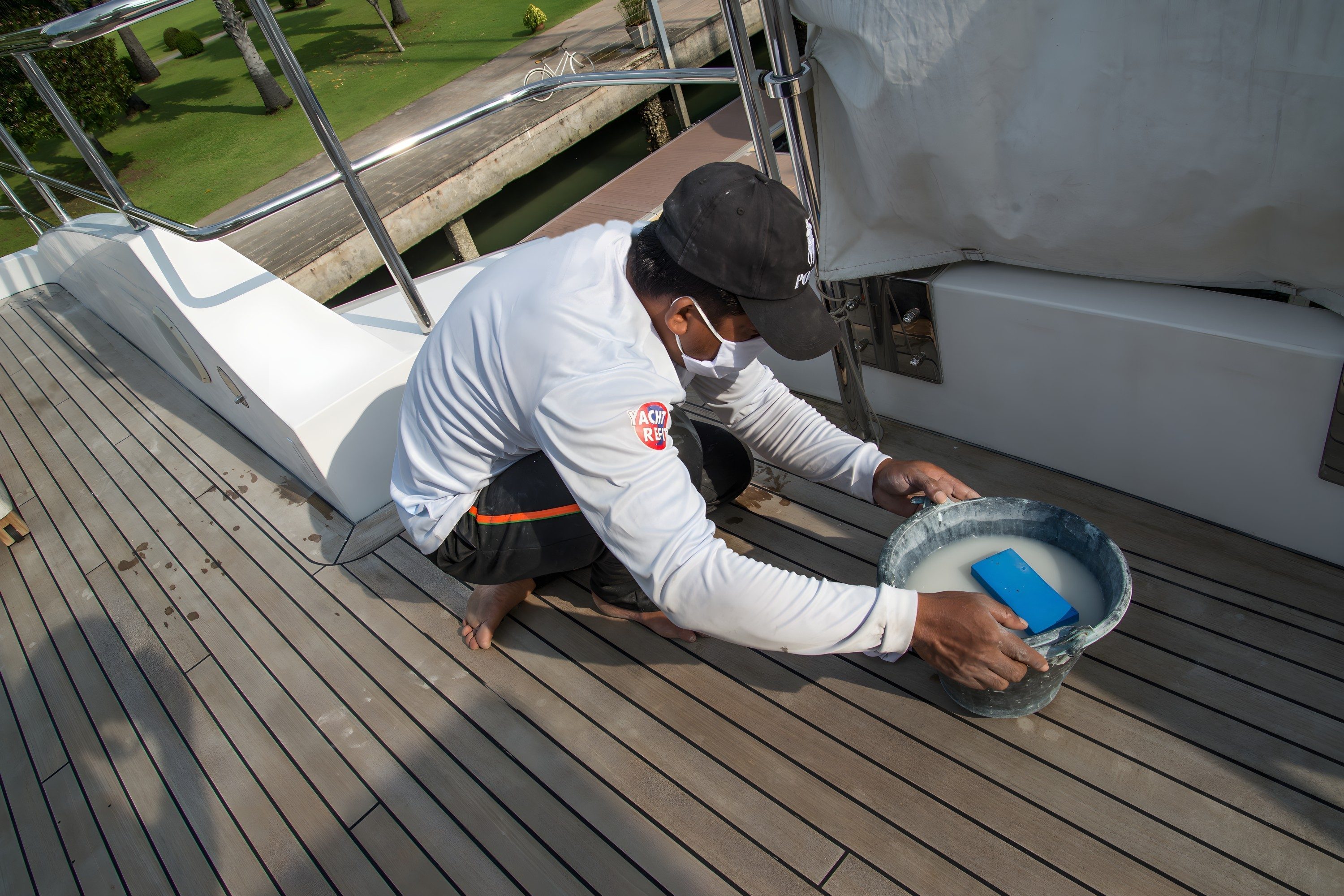Gloss white topsides and superstructure on a motor yacht alongside a pontoon